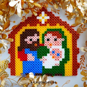 Peut inclure: Une sc&egrave;ne de la nativit&eacute; en pixel art avec un Joseph &agrave; la peau brune, une Marie v&ecirc;tue de vert et un b&eacute;b&eacute; J&eacute;sus blanc. La sc&egrave;ne se d&eacute;roule dans une &eacute;table brune et jaune avec une &eacute;toile blanche au-dessus.