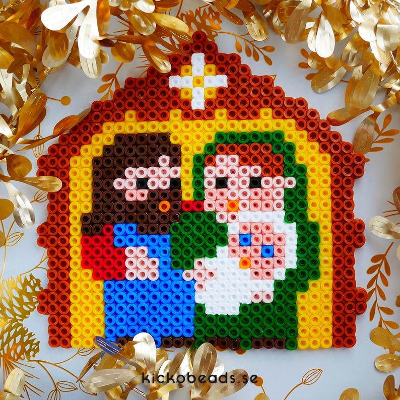 Peut inclure: Une sc&egrave;ne de la nativit&eacute; en pixel art avec un Joseph &agrave; la peau brune, une Marie v&ecirc;tue de vert et un b&eacute;b&eacute; J&eacute;sus blanc. La sc&egrave;ne se d&eacute;roule dans une &eacute;table brune et jaune avec une &eacute;toile blanche au-dessus.