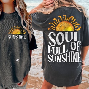 May include: Two people wearing gray t-shirts with a vintage sun graphic and the text "Sunshine" and "Soul Full of Sunshine".