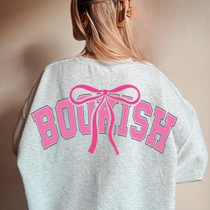 May include: Gray sweatshirt with a pink bow and the word "BOOKISH" printed in pink and black on the back.