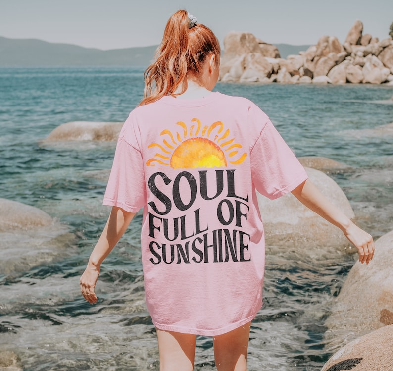 May include: A pink t-shirt with a graphic of a sun and the text "Soul Full of Sunshine".