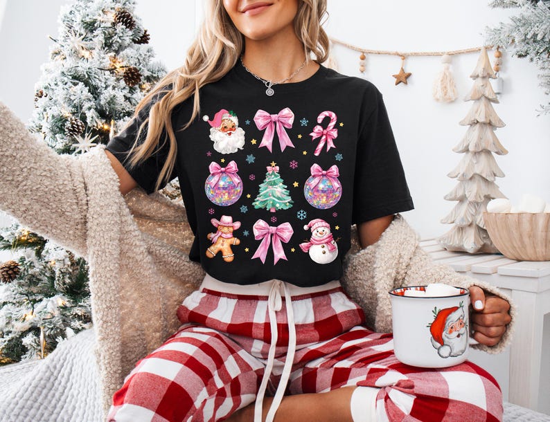 May include: A black t-shirt with a Christmas-themed design featuring Santa, a gingerbread person, a snowman, ornaments, bows, and candy canes.