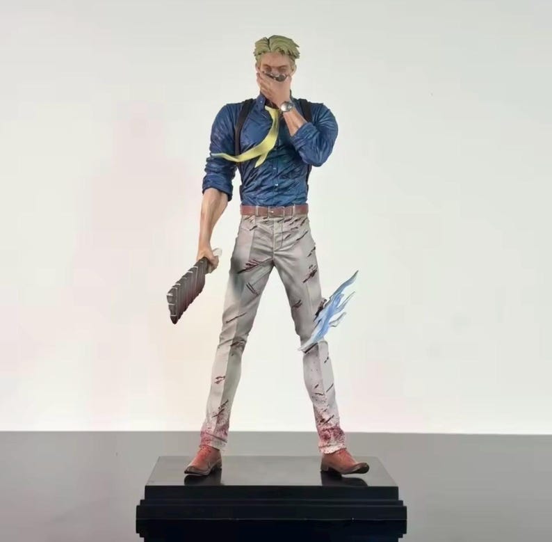 May include: A detailed figurine of a character in a blue shirt, gray pants, and brown boots, holding a weapon and a blue energy effect. The figure has blonde hair and a yellow tie. The figurine stands on a black base.