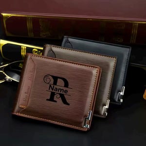 May include: Three leather wallets in brown, tan, and black. The front wallet is brown with the name "Men Bense" and a large letter "R" with the word "Name" below it. The wallets have silver corner accents.