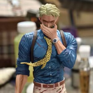 May include: A figurine of a character with blond hair, wearing a blue shirt, tan pants, and a yellow patterned tie. The figure has a watch and sunglasses. The figure is holding a hand up to its face.