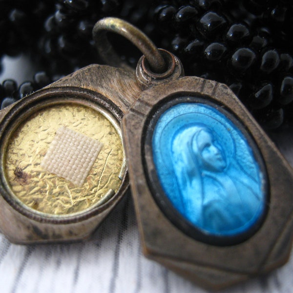 Antique French catholic blue enamel silver plated slide locket shrine medal pendant charm with relic cloth touched at Saint Bernadette.