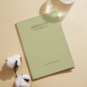 May include: A green journal with the text "Anxiety Scribbles" and "The Intentional Writers" on the cover.