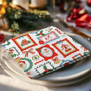 Pu&ograve; includere: Una pila di tovaglioli di carta quadrati con sfondo bianco e un motivo ripetuto di cornici colorate a tema natalizio. Le cornici contengono illustrazioni di una casa rossa, una giostra, un pupazzo di neve e Babbo Natale, decorate con agrifoglio.