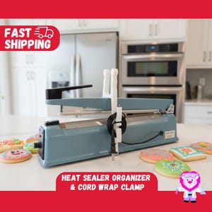 May include: A teal heat sealer with a black handle and white cord wrap clamp. The image also shows decorated cookies. Text on the image reads "Heat Sealer Organizer & Cord Wrap Clamp."