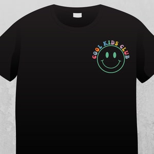 May include: Black t-shirt with a colorful "Cool Kids Club" graphic featuring a green smiley face.