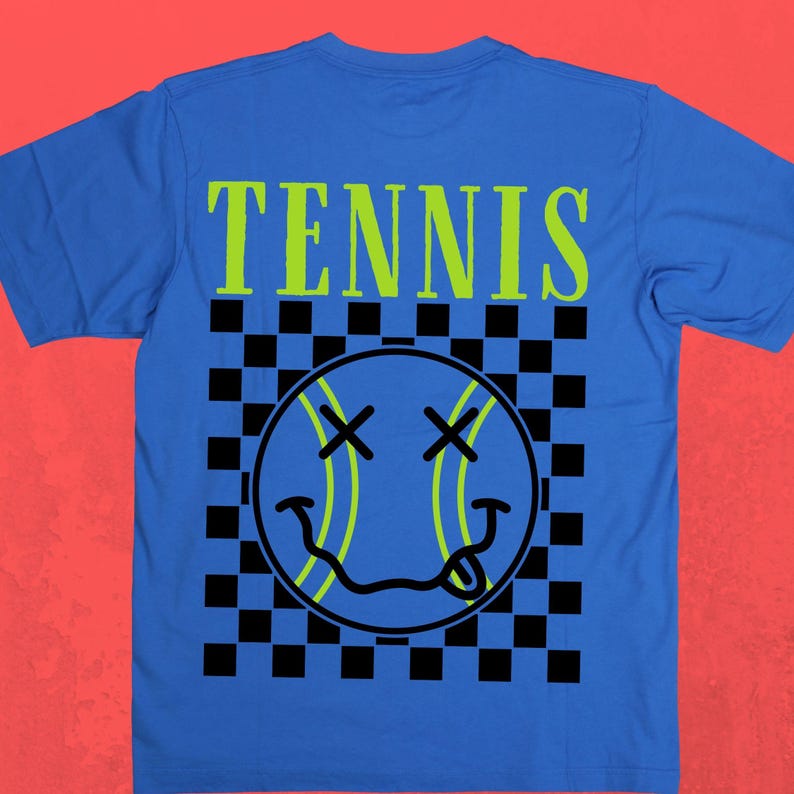 May include: A royal blue t-shirt with a black and white checkered pattern and a green smiley face tennis ball graphic. The text "TENNIS" is printed in green above the graphic.