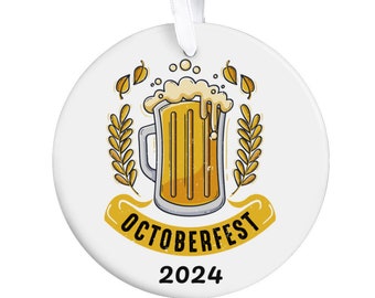 May include: White round bauble featuring a yellow beer stein illustration and the text "Oktoberfest 2024".