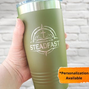 May include: A green stainless steel tumbler with a compass design and the words "Steadfast" and "1 Corinthians 15:58".