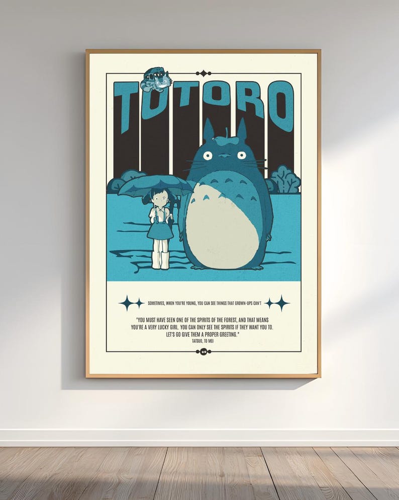 Może przedstawiać: Oprawiony plakat z napisem "TOTORO" w kolorze niebieskim nad ilustracją dużej, niebieskiej, włochatej istoty i młodej dziewczyny. Plakat zawiera cytat o duchach i lesie.