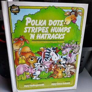 May include: A children's book titled "Polka Dots, Stripes, Humps 'N Hatracks" with a green tree design and cartoon animals. The cover features the text "How God Created Happy Forest" and the authors' names.