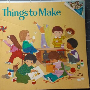 May include: A vintage children's book titled "Things to Make" with illustrations of children crafting. The cover is yellow with the title in teal. The illustrations depict children creating art and playing with toys.