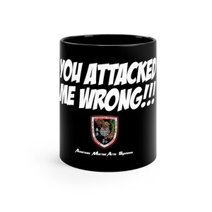 May include: Black coffee mug with white text that reads "You attacked me wrong!!" and a black and red logo that reads "American Martial Arts Systems".