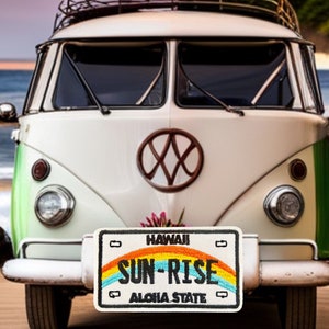 May include: A white vintage Volkswagen van with a rainbow license plate that reads "HAWAII SUN-RISE ALOHA STATE".