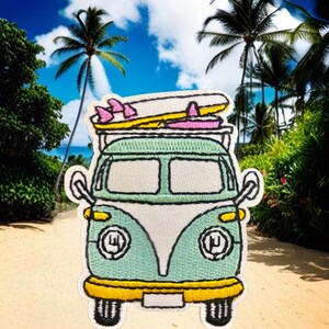 May include: A green and white vintage van with surfboards on top, driving on a sandy beach with palm trees in the background.