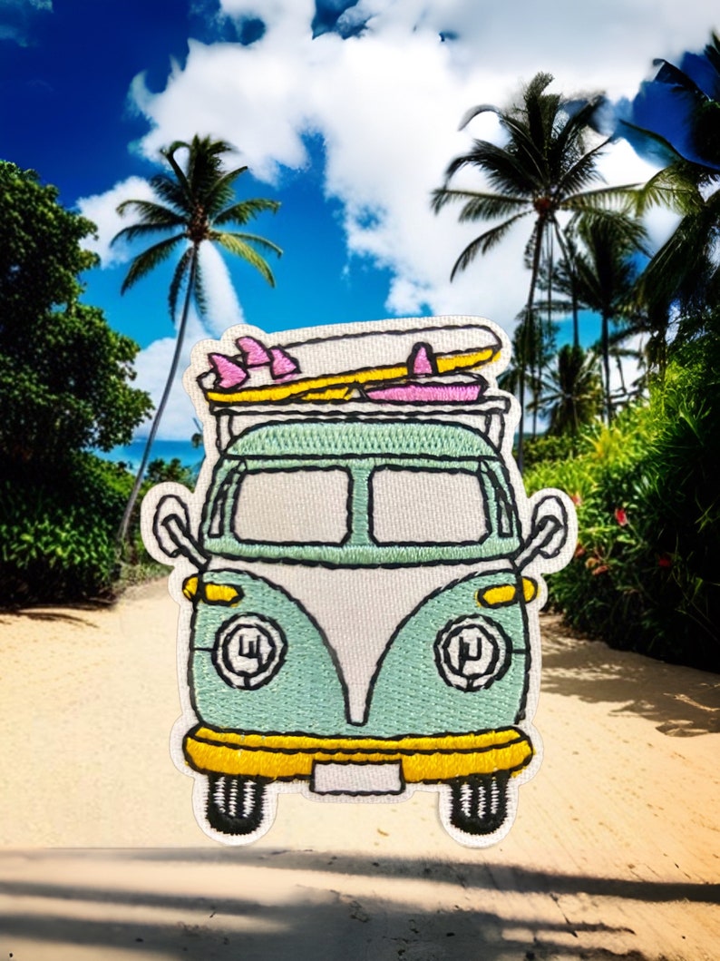 May include: A green and white vintage van with surfboards on top, driving on a sandy beach with palm trees in the background.