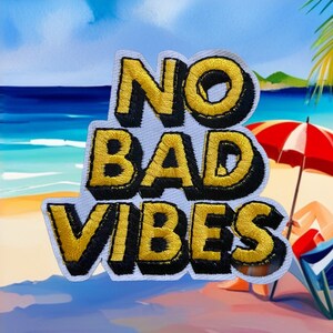 May include: A white patch with black and yellow embroidered text that reads "NO BAD VIBES". The patch is in front of a painting of a beach scene with a red umbrella and a person sitting on a beach chair.