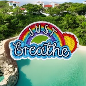 May include: A rainbow-colored embroidered patch with the words "JUST Breathe" in white lettering. The rainbow has a yellow sun at the end.