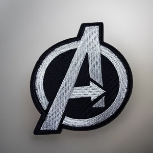 Può includere: Una toppa ricamata in bianco e nero con il logo degli Avengers, una "A" stilizzata all'interno di un cerchio.