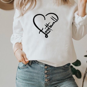 May include: White sweatshirt with a black heart design that says "Football" inside the heart.