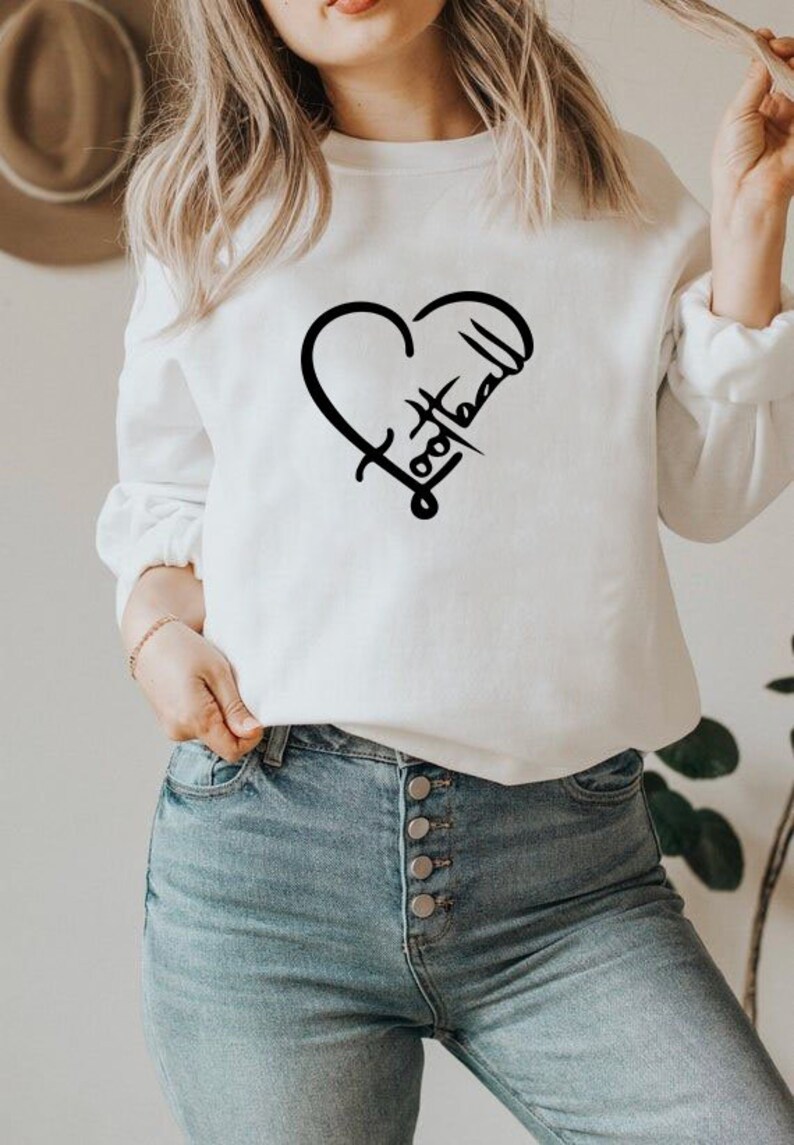 May include: White sweatshirt with a black heart design that says "Football" inside the heart.
