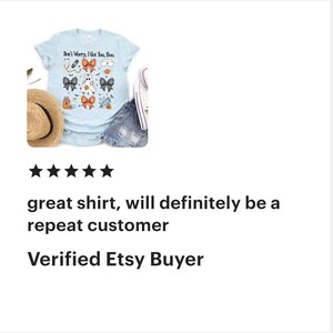 May include: Pale blue t-shirt with the phrase "Don't Worry, I Got You, Boo." The shirt displays Halloween-themed graphics such as a ghost, bows, pumpkins, and medical symbols. A straw hat, denim shorts, and a white shoe are also visible.