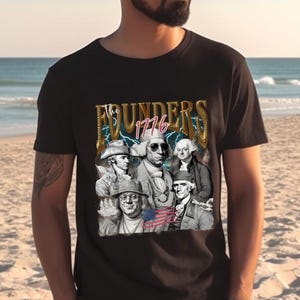 May include: A black t-shirt with a graphic print of the Founding Fathers of the United States. The graphic features the text "The Founders 1776" in gold lettering with lightning bolts. The Founding Fathers are depicted in a vintage style with sunglasses and hats.