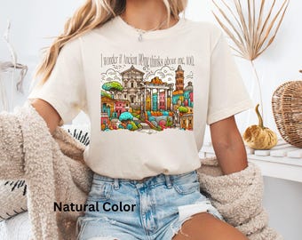 May include: A white t-shirt with a colorful illustration of the Roman Colosseum and the text "I wonder if Ancient Rome thinks about me, too."
