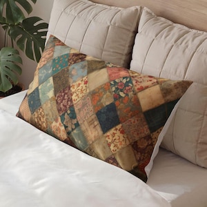 May include: Rectangular pillow with a patchwork design. The pillow features a variety of fabric squares in shades of blue, green, pink, and brown, with floral and patterned motifs. The pillow is placed on a white bed with beige pillows.