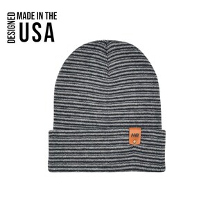 May include: A gray and black striped beanie with a folded brim. The hat has a small brown leather tag with the letters "HW" on it. The text "MADE IN THE USA" is printed on the left side of the image.