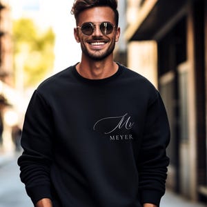 Peut inclure: Un sweat-shirt noir avec une inscription cursive blanche qui dit "Mr. Meyer".