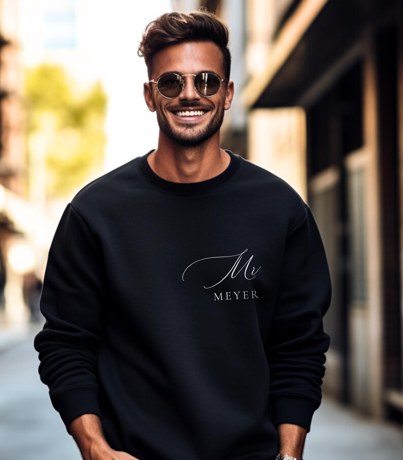 Peut inclure: Un sweat-shirt noir avec une inscription cursive blanche qui dit "Mr. Meyer".