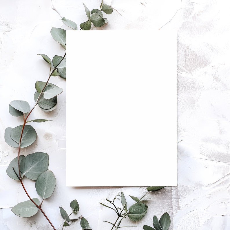 Puede incluir: Una maqueta de tarjeta blanca con una superficie blanca en blanco, rodeada de hojas de eucalipto verdes sobre un fondo blanco texturizado.
