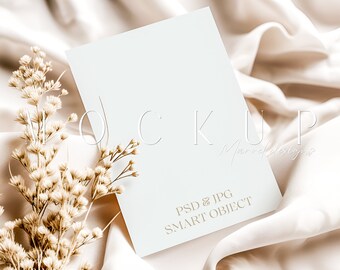 May include: A white card mockup with the text "PSD & JPG SMART OBJECT" on a beige fabric background with dried flowers.