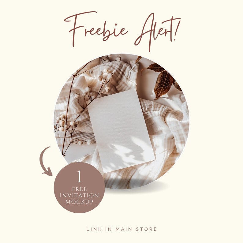 May include: A blank white invitation mockup is centered on a beige fabric, surrounded by dried flowers and leaves. The text "Freebie Alert!" is written in a brown script font. A brown circle indicates "1 Free Invitation Mockup".