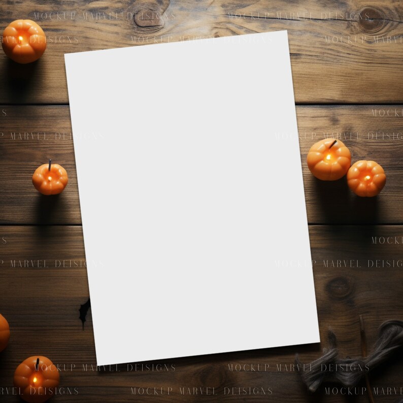 Op de afbeelding: Een blanco wit vel papier ligt op een houten tafel met verschillende kleine oranje pompoenvormige kaarsen eromheen.