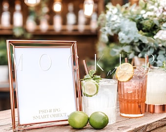 Può includere: Una cornice color rame con la parola "MOCKUP" sullo sfondo. Due lime verdi sono su una superficie di legno accanto a tre bicchieri di cocktail. Il testo "PSD & JPG SMART OBJECT" è visibile.