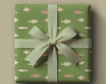 May include: A square gift wrapped in green paper with a fish pattern. The gift is tied with a light green ribbon and bow. The fish are white and red, and the background is a textured green.