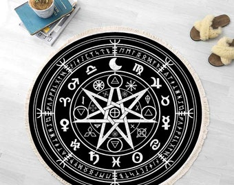 Op de afbeelding: Rond zwart-wit tapijt met een pentagram-ontwerp en astrologische symbolen. Het tapijt heeft een witte franje rand.