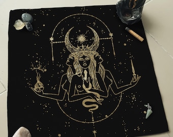 May include: A black canvas tapestry with a gold design of a three-faced goddess figure with a snake wrapped around her. The goddess is surrounded by a crescent moon and stars.