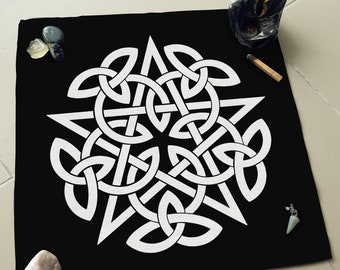 May include: A black cloth with a white Celtic knot design. The knot is a complex pattern of interwoven lines that form a circle.