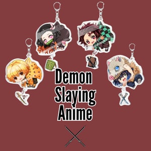Könnte beinhalten: Acryl-Schlüsselanhänger mit Charakteren aus der Anime-Serie Demon Slayer. Die Schlüsselanhänger zeigen farbenfrohe Illustrationen der Charaktere mit silberfarbenen Schlüsselringen. Der Text "Demon Slaying Anime" wird in der Mitte des Bildes mit gekreuzten Schwertern darunter angezeigt.