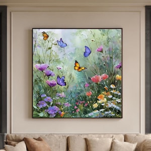 Puede incluir: Pintura enmarcada de un campo de flores silvestres con mariposas. La obra presenta flores moradas, naranjas y azules. La pintura cuelga sobre un sofá beige en un salón.