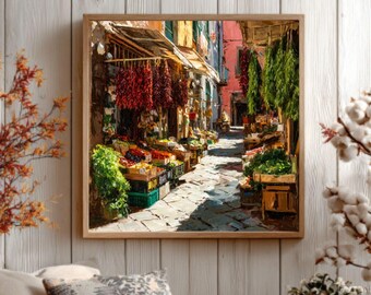 May include: A framed print depicts a vibrant Italian market scene. The artwork showcases a narrow cobblestone street lined with stalls overflowing with produce and hanging red peppers. The scene is bathed in sunlight, with colorful buildings and awnings.