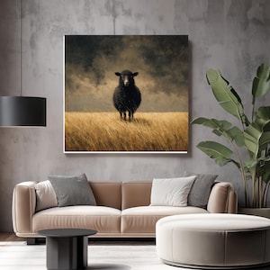 K&ouml;nnte beinhalten: Gerahmter Kunstdruck mit einem schwarzen Schaf, das in einem Feld aus goldenem Gras unter einem bew&ouml;lkten Himmel steht. Das Kunstwerk hat einen rustikalen, malerischen Stil und wird in einem modernen Wohnzimmer pr&auml;sentiert.