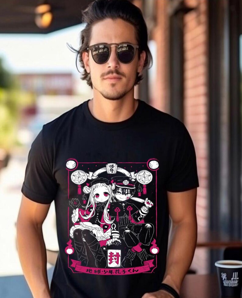 May include: Black t-shirt with a white and pink graphic print of two anime characters. The characters are sitting on a throne with a pink background. The text "地縛少年花子くん" is printed below the characters.